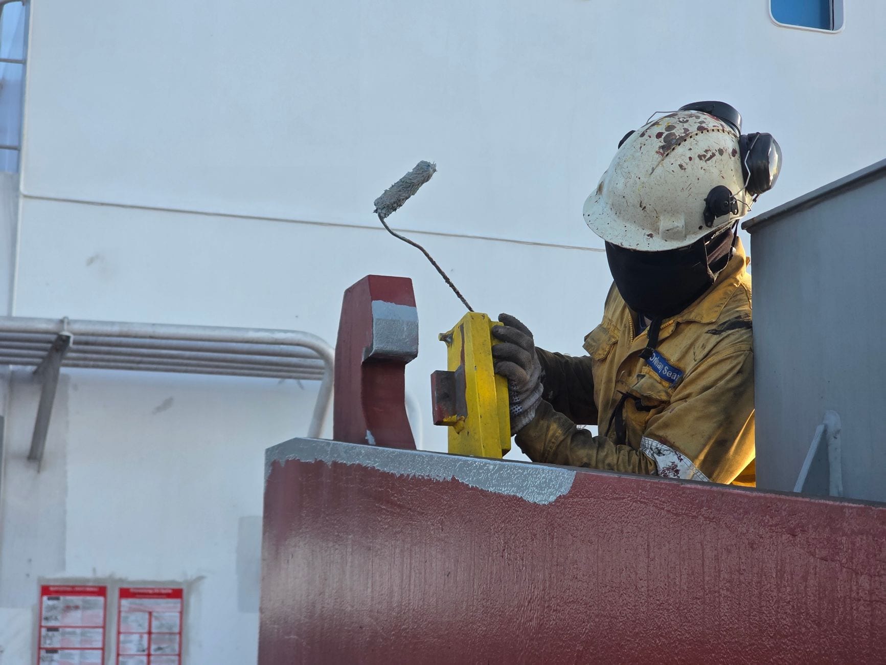 Painter applying a second coat to a commercial shopfront
