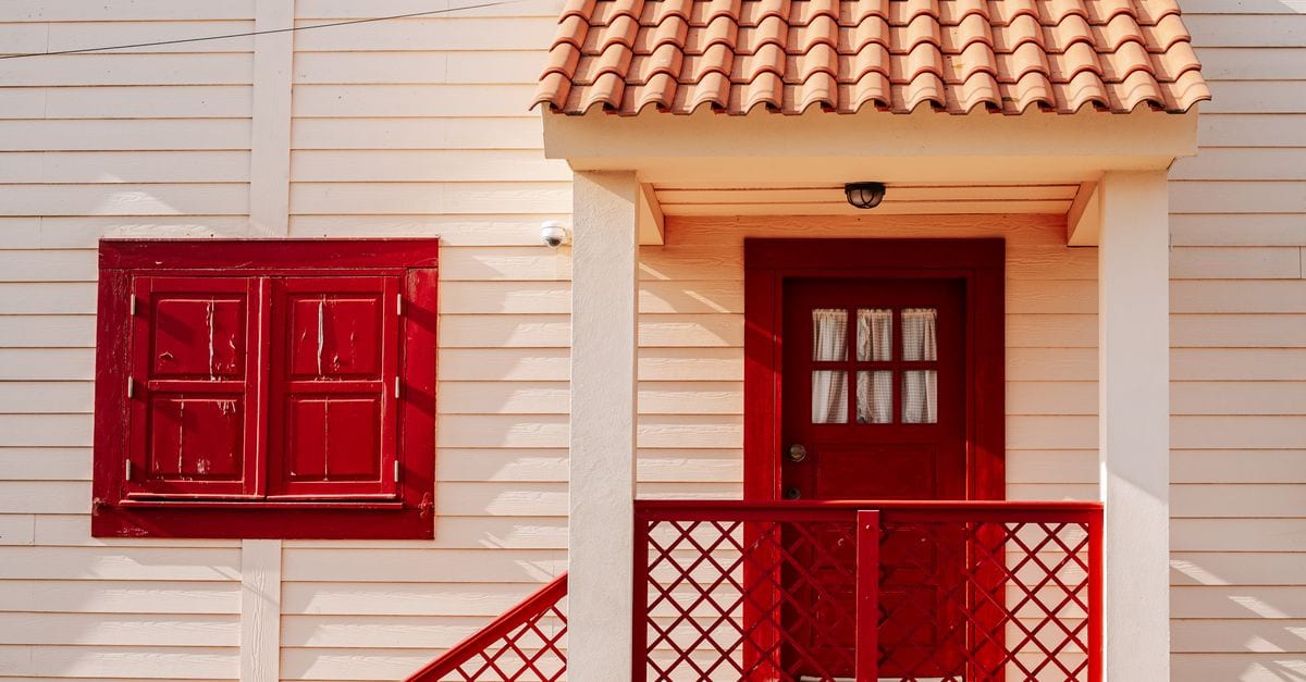 A painter applying a coat to a house exterior